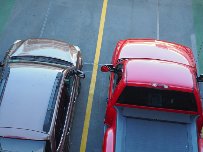 Improperly parked cars in a parking lot, illustrating male Karen refusing to park his car right despite neighbor's warning. Improperly parked cars in a parking lot, illustrating male Karen refusing to park his car right despite neighbor's warning.