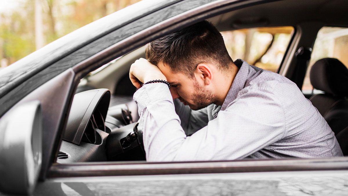 Male Karen frustrated inside his car after neighbor takes revenge for improper parking causing tension.