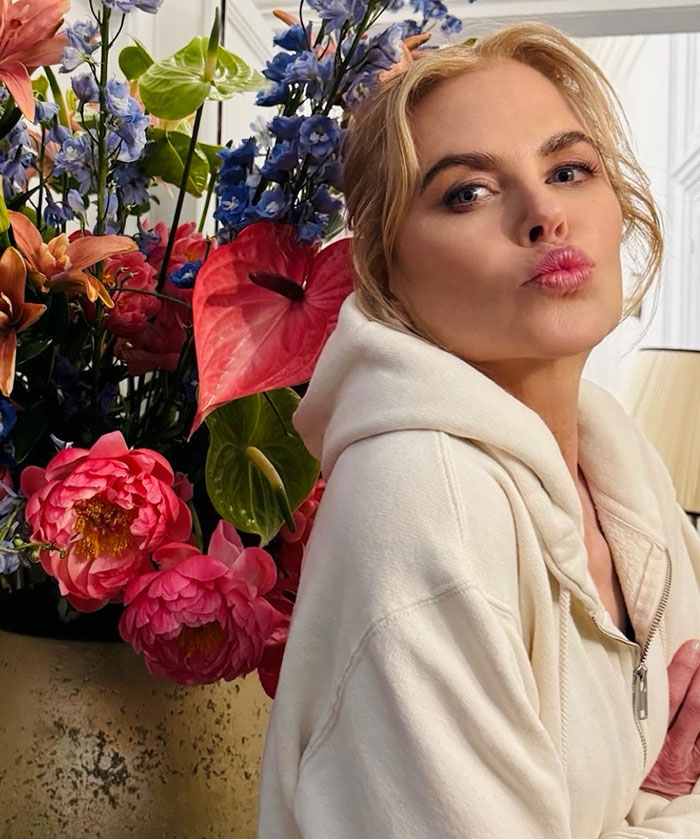 Nicole Kidman posing in a cream hoodie with colorful flowers in the background in an update on divorce criticism. Nicole Kidman posing in a cream hoodie with colorful flowers in the background in an update on divorce criticism.