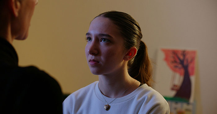 Teen girl with depression looking upset during a serious conversation with parents about removing her mattress and sleep habits Teen girl with depression looking upset during a serious conversation with parents about removing her mattress and sleep habits