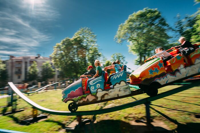 Children enjoying a colorful amusement park ride on a sunny day, capturing moments of crazy coincidences experienced.