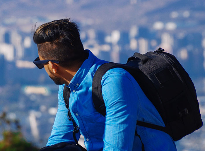 Man with backpack looking over cityscape, representing people who walked away and started new lives.