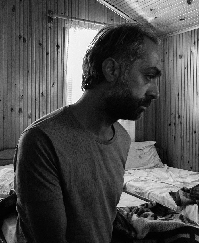 Man in a wooden room reflecting, representing people who walked away from their old lives and started a new one.