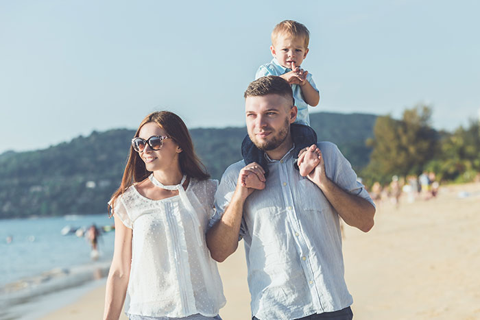 Family enjoying a beach walk, representing people who walked away from their old lives and started a new one.