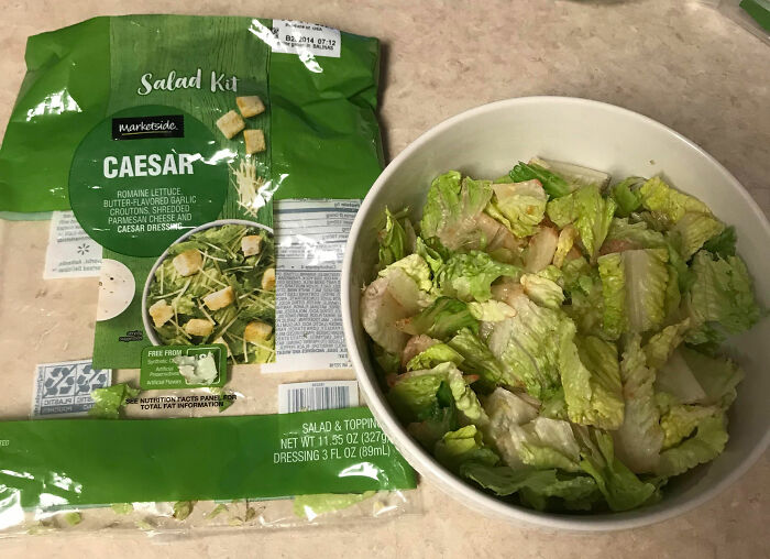 Caesar salad kit with romaine lettuce and dressing prepared in a bowl illustrating kitchen tips and tricks.