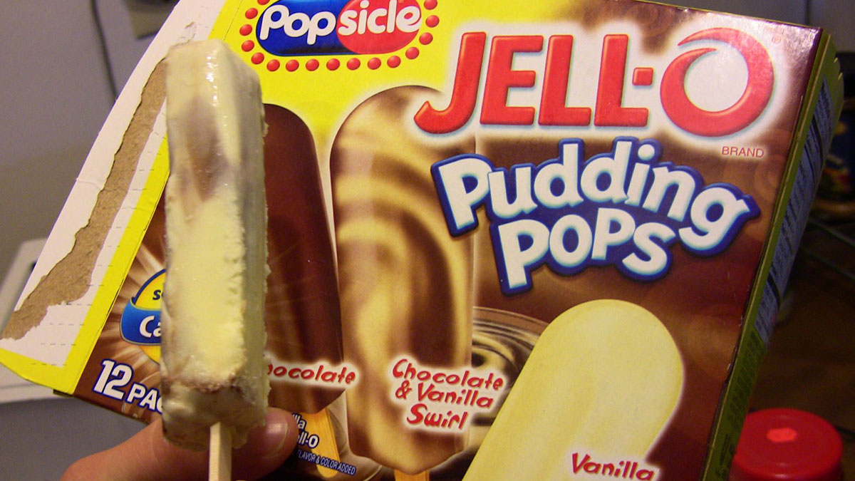 Hand holding a discontinued JELL-O Pudding Pops box featuring chocolate and vanilla swirl frozen treats.