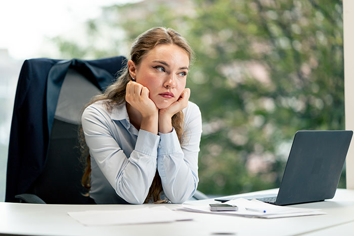 Woman at office desk looking frustrated, representing coworkers who keep Venmo ghosting the birthday organizer.