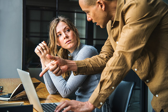 Woman refusing to return coworker’s expensive jacket while having a tense conversation at office desk with laptop. Woman refusing to return coworker’s expensive jacket while having a tense conversation at office desk with laptop.