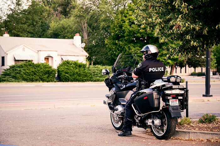 Police officer in uniform on a motorcycle, illustrating challenges of getting in the U.S. police force today.
