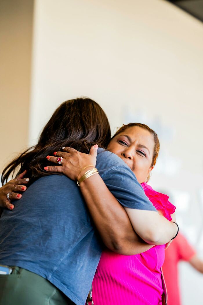 Two women embracing warmly indoors, capturing a moment of emotional connection and childhood habits realization.