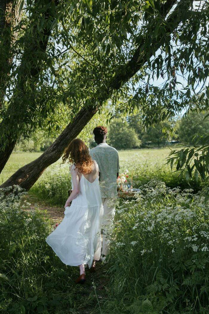 Two people walking through lush greenery under a tree, illustrating themes of life and rebirth after dying experiences.