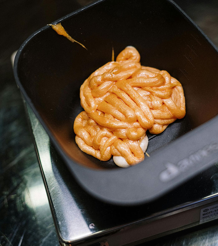 Orange hair dye paste in a black bowl ready for dyeing hair orange in classmate drama scene. Orange hair dye paste in a black bowl ready for dyeing hair orange in classmate drama scene.