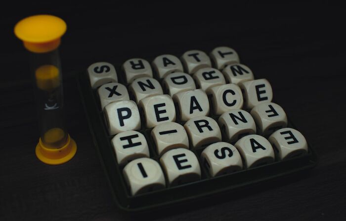 Hourglass next to lettered dice spelling peace, highlighting childhood habits that were anything but normal.