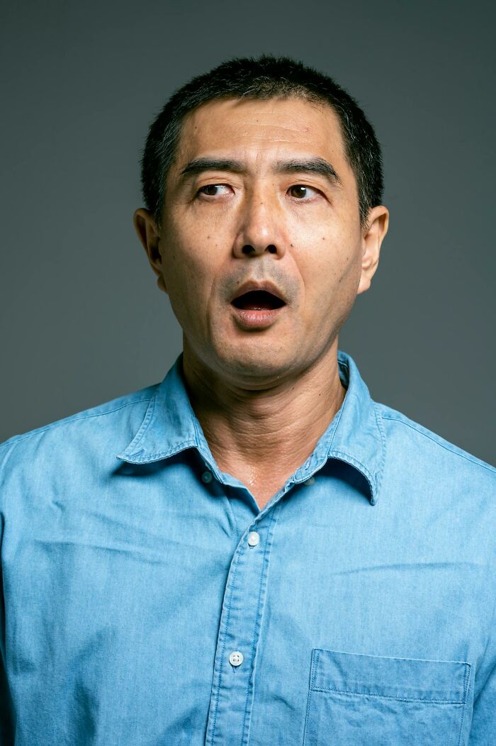 Man with surprised expression wearing a blue shirt, symbolizing heavy confessions people refused to take to their graves.