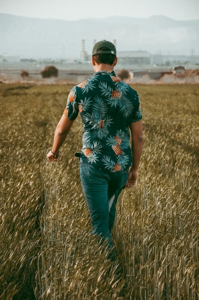 Man in a pineapple shirt walking through a field, symbolizing people who came back to life sharing their dying experiences.