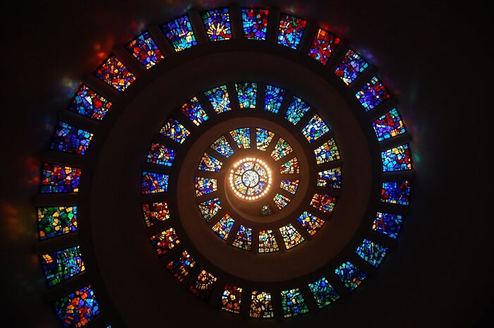 Spiral stained glass windows with colorful light, illustrating themes related to people who came back to life.