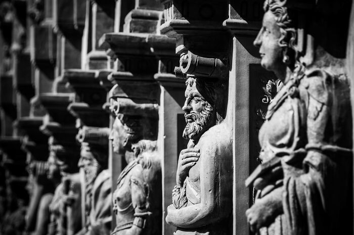 Black and white image of ancient stone sculptures lined up, illustrating historical figures in detailed relief art. Black and white image of ancient stone sculptures lined up, illustrating historical figures in detailed relief art.