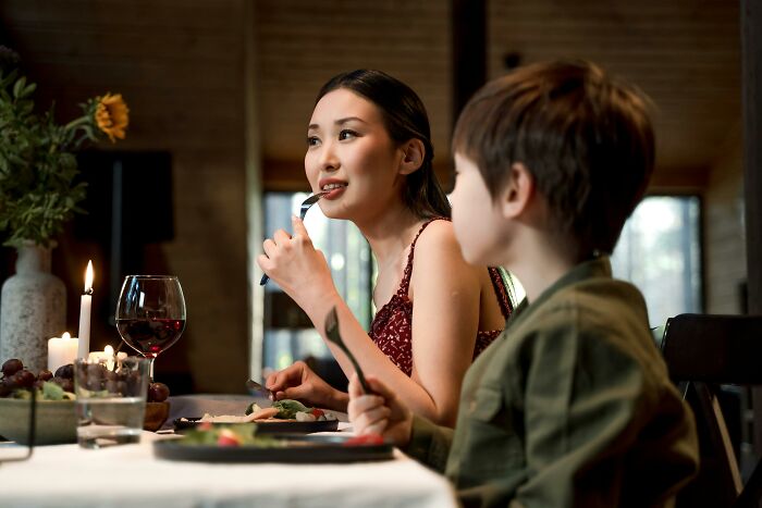 Woman and child having dinner by candlelight, capturing a moment related to real-life horror story experiences.