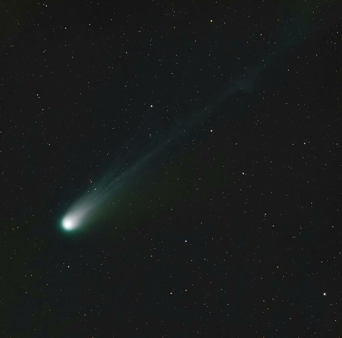 Bright comet streaking across the starry night sky, capturing one of the bizarre moments that make people wonder.
