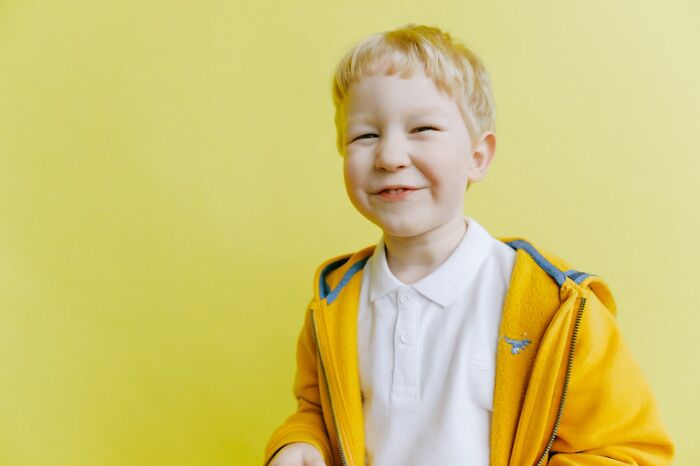 Smiling young boy in a yellow jacket showing funny and serious moments of parents raising monsters against yellow background.