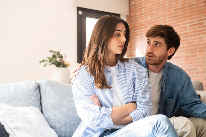 A jealous wife upset on couch as hubby tries to calm her over his mom having pics of his ex in her house. A jealous wife upset on couch as hubby tries to calm her over his mom having pics of his ex in her house.