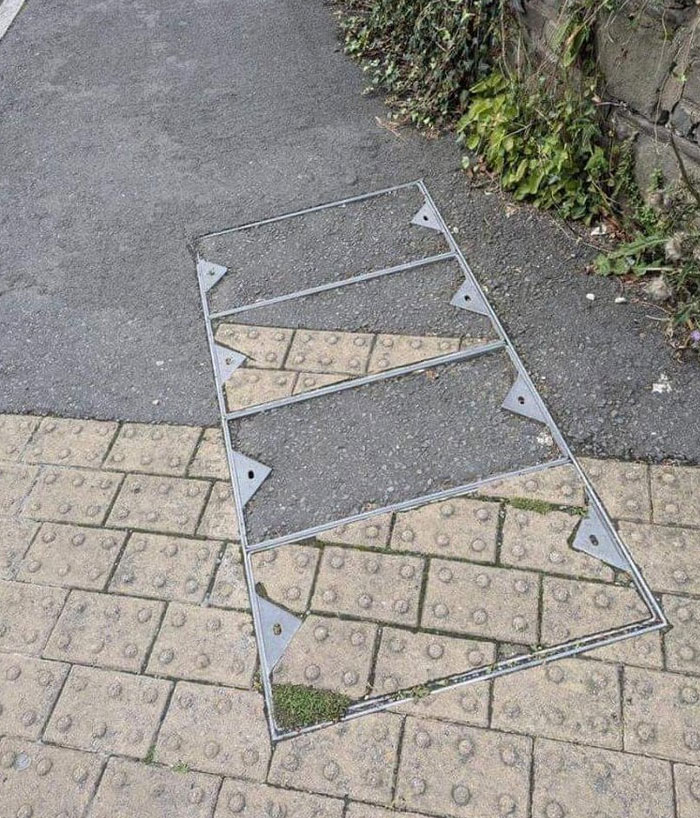  sidewalk design and architecture nightmare with misaligned paving stones inside metal frame on uneven ground