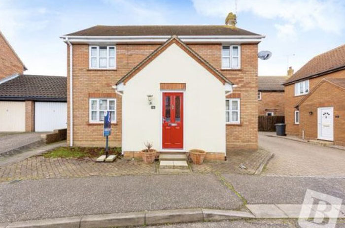 Two-story brick house with a red front door and poorly aligned driveway illustrating design and architecture nightmares.