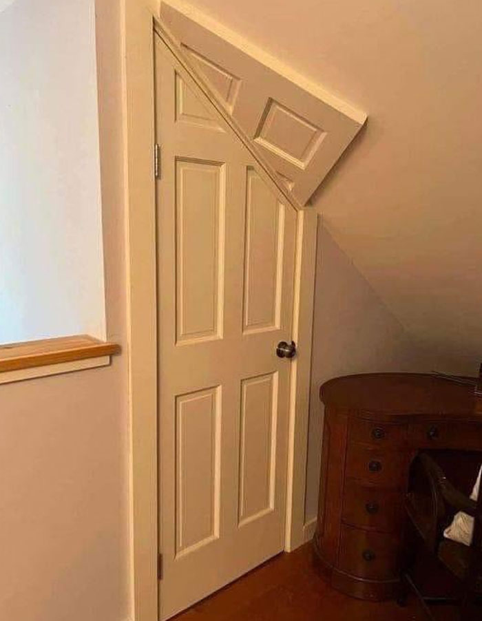 Door with a triangular cutout at the top to fit under a sloping ceiling, a design and architecture nightmare example.