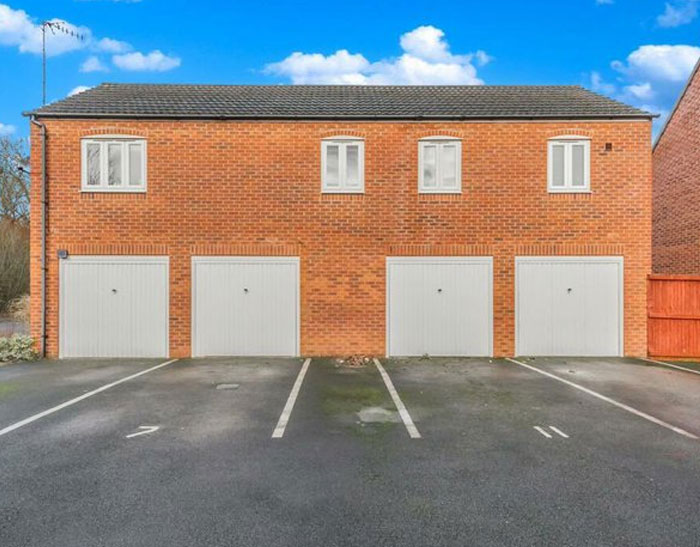 Four garage doors under windows with no driveway space, showcasing a common design and architecture nightmare.