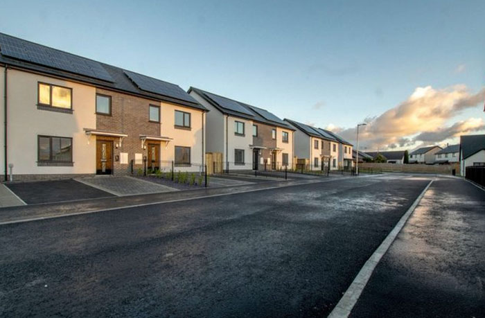 Row of modern houses with solar panels on roofs, illustrating design and architecture nightmares in residential planning.