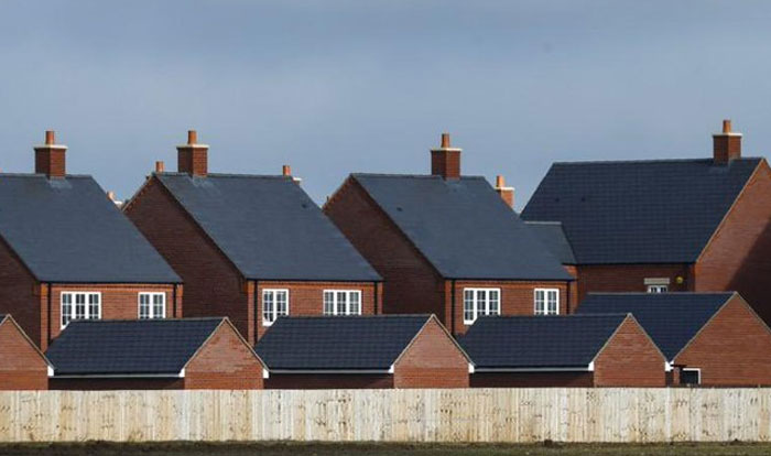 Row of identical brick houses with dark roofs illustrating design and architecture nightmares in suburban development.