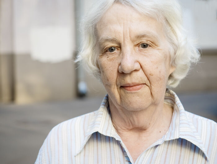 Elderly woman with white hair looking thoughtfully, representing creepy cases doctors and nurses can never forget.