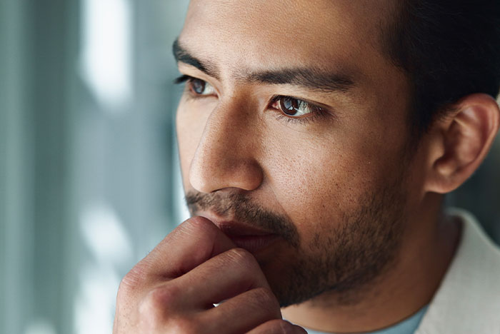 Close-up of a man deep in thought, reflecting on issues related to pregnant girlfriend refusing to move together.