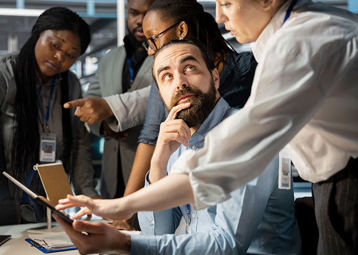 A diverse team discussing psychological tricks people use on themselves and others during a focused workplace meeting.