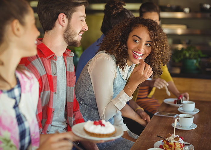 A group of friends enjoying dessert and coffee together, illustrating psychological tricks people use on themselves and others.