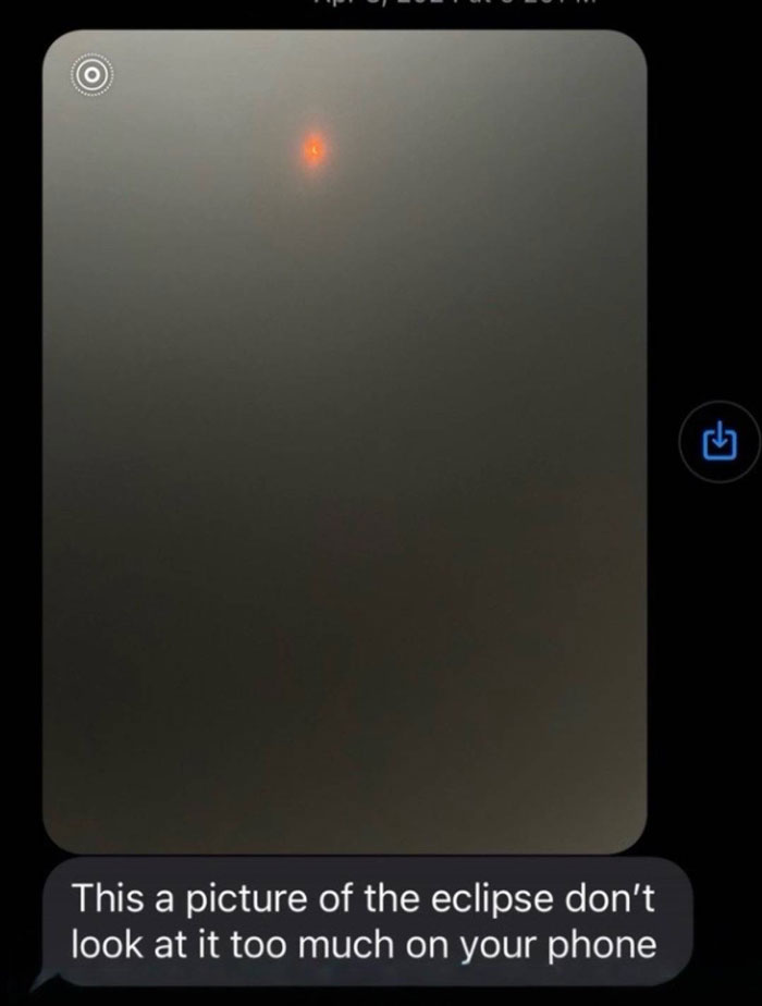 Screenshot of an unhinged text message from a parent warning about looking at the eclipse on a phone, humorous trend.