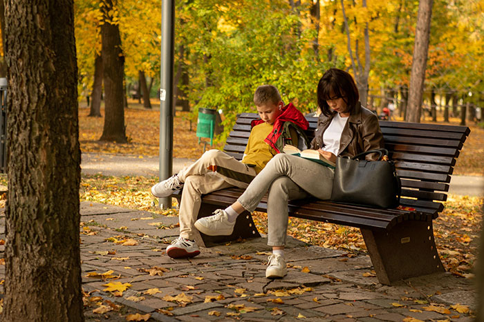 Mother and child sitting on a park bench in autumn, reflecting on honest reasons why parents were unhappy.