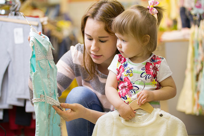 Mother and young daughter shopping for clothes together, illustrating parents and children sharing honest reasons for unhappiness.