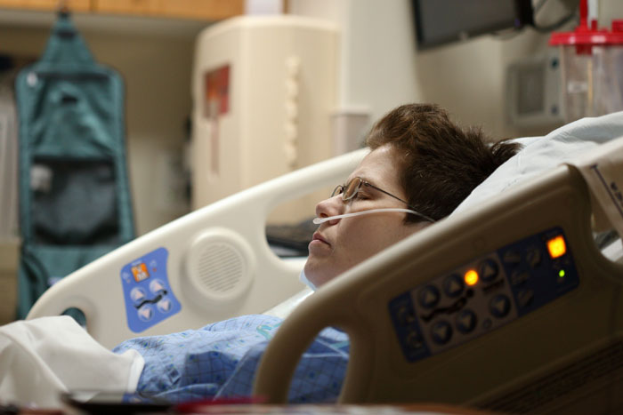 Nonverbal, bedridden boy lying in hospital bed with oxygen tube, appearing to rest in a medical care setting. Nonverbal, bedridden boy lying in hospital bed with oxygen tube, appearing to rest in a medical care setting.