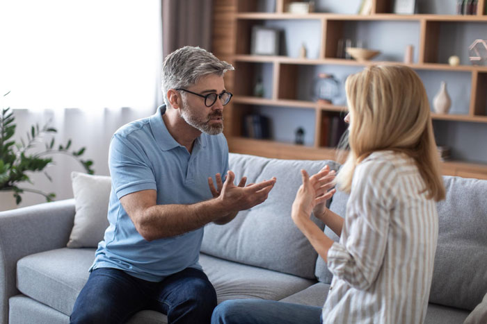 Middle-aged man and young woman having a serious discussion at home about inheritance and spending on a BBL. Middle-aged man and young woman having a serious discussion at home about inheritance and spending on a BBL.