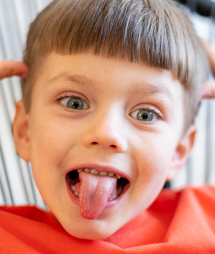 Close-up of a playful child sticking out tongue, illustrating how people's lies can get out of hand and change their lives.