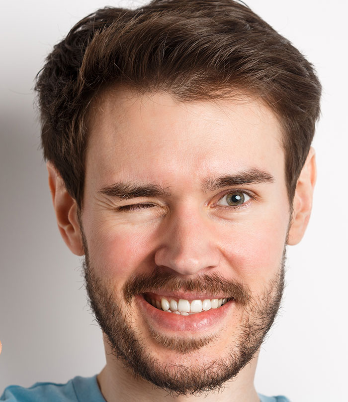 Young man winking and smiling, representing people's lies that got out of hand and changed their lives dramatically.