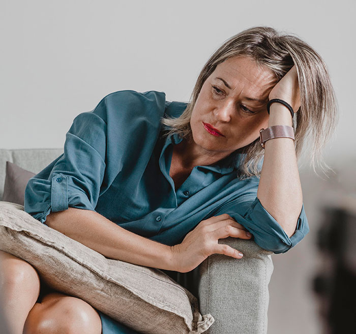 Woman in a teal shirt looking troubled and reflective, illustrating times people's lies got out of hand and impacted lives.