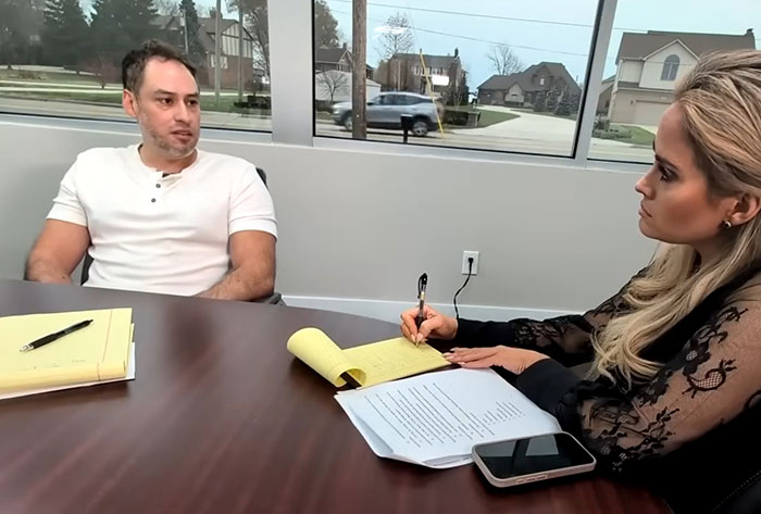 Man in white shirt and woman taking notes during an interview about Campbell's executive disturbing comments on soup ingredients. Man in white shirt and woman taking notes during an interview about Campbell's executive disturbing comments on soup ingredients.