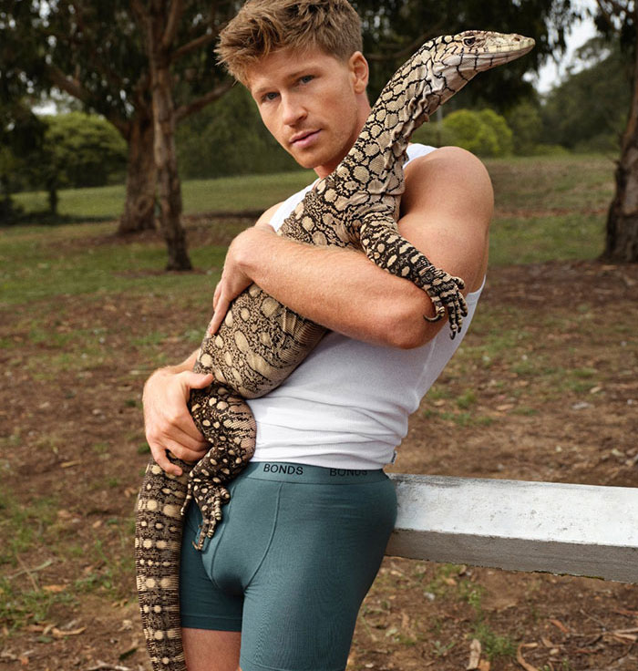 Shirtless man wearing Bonds underwear with a large snake draped over his shoulders in an outdoor rural setting. Shirtless man wearing Bonds underwear with a large snake draped over his shoulders in an outdoor rural setting.