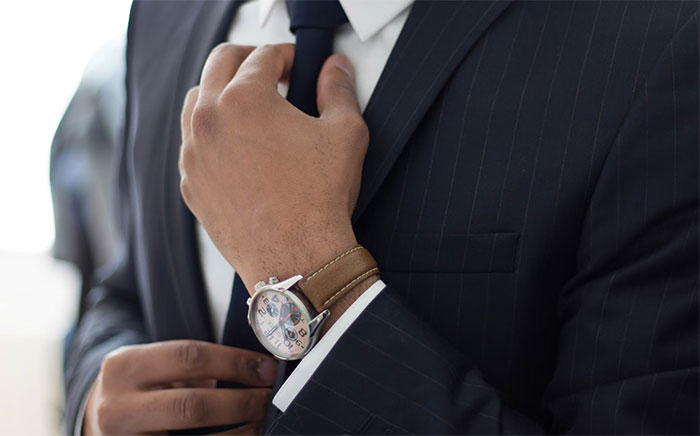 Man adjusting tie wearing suit and watch, symbolizing a guy deciding to finally propose after 30 years and 4 kids. Man adjusting tie wearing suit and watch, symbolizing a guy deciding to finally propose after 30 years and 4 kids.