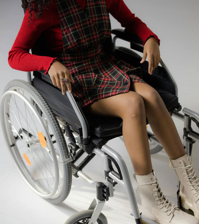 Teen in wheelchair wearing a red sweater and plaid dress, reflecting the sad teen refuses visit special needs stepsister theme. Teen in wheelchair wearing a red sweater and plaid dress, reflecting the sad teen refuses visit special needs stepsister theme.