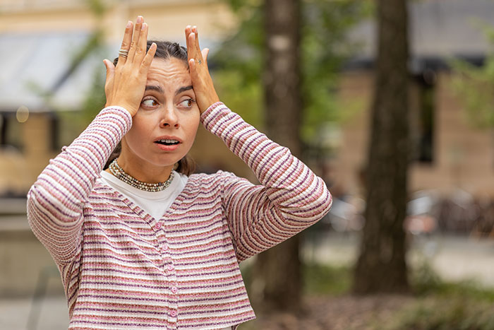 Woman in striped sweater looking worried and surprised, as fiance detective treats partner suspicious behavior outside. Woman in striped sweater looking worried and surprised, as fiance detective treats partner suspicious behavior outside.