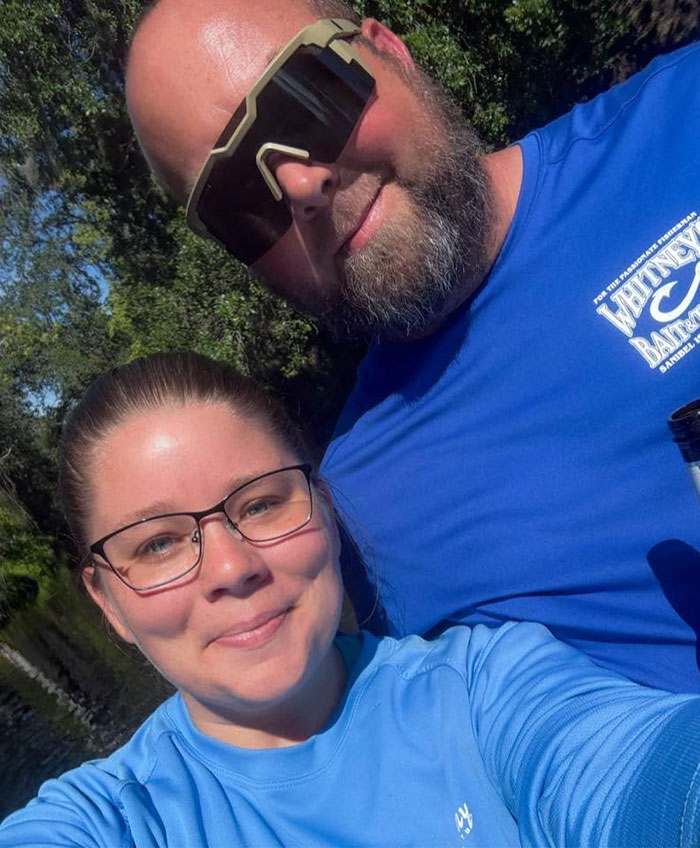 Two people outdoors wearing blue shirts and sunglasses, unrelated to stepsibling investigation after teen's body found on Carnival cruise. Two people outdoors wearing blue shirts and sunglasses, unrelated to stepsibling investigation after teen's body found on Carnival cruise.
