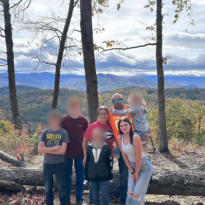 Family posing outdoors in a forested mountain area, related to father of teen slain on cruise and babysitter affair allegations. Family posing outdoors in a forested mountain area, related to father of teen slain on cruise and babysitter affair allegations.